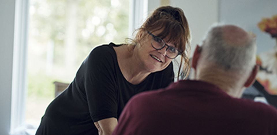 Hjælper interagerer med ældre borger