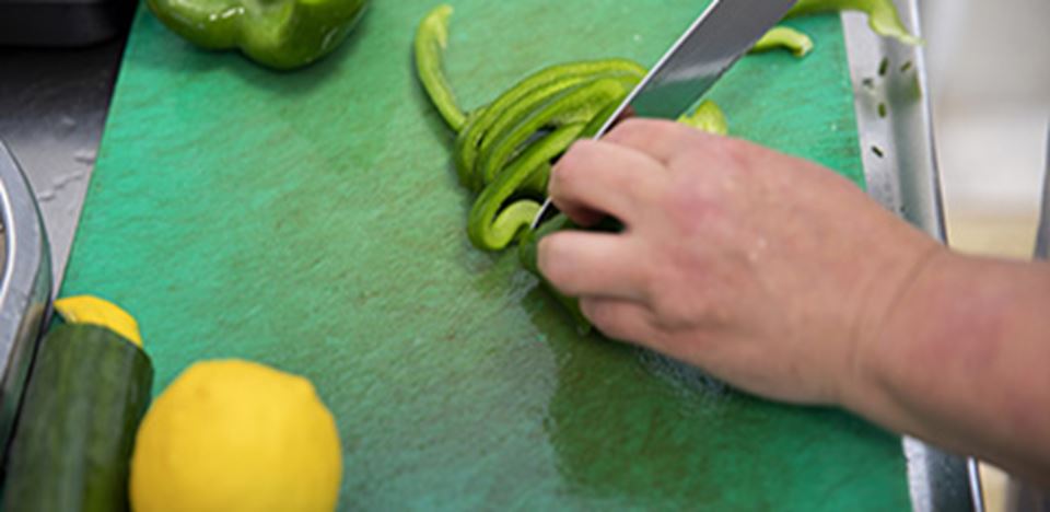 Grønt skærebræt med citron, agurk og grøn peberfrugt